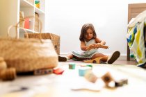 Carino bambina giocare con rotaie treno in legno nella sua camera da letto — Foto stock
