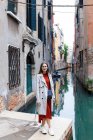 Joven turista en traje y abrigo en las calles de Venecia - foto de stock