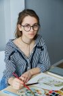 Millennial Girl zeichnet fabelhafte Bilder auf Papier, während sie zu Hause sitzt — Stockfoto