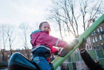Молода дівчина грає в парку в Швеції на заході сонця з татом. — стокове фото