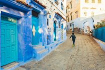 Local boy running in the street of Chefchaouen blue village — Stock Photo