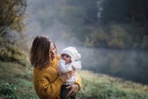 Beautiful young mother with her baby on nature — Stock Photo