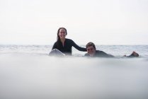 Amigos divirtiéndose surfeando en verano - foto de stock