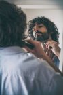 Young man trimming his beard. Lifestyle — Stock Photo
