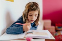 Мила дівчина дивлячись на її домашнє завдання — стокове фото