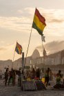 Hermosa vista a las banderas y locales durante el atardecer en la playa de Copacabana - foto de stock