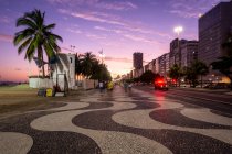 Belle vue sur le coucher du soleil à Copacabana Beach promenade et bâtiments — Photo de stock