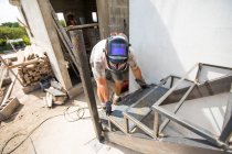 Mann arbeitet auf Baustelle, baut Treppe — Stockfoto