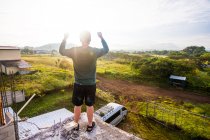 Man praising God from rooftop at sunrise. — Stock Photo