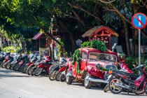 Motos e velhinho estacionado ao longo de uma rua em Luang Prabang — Fotografia de Stock