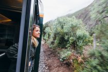 A young woman is looking out of a window on the way to Machu Picchu — Stock Photo