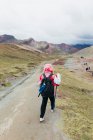 Una giovane donna sta camminando verso la famosa Montagna Arcobaleno in Perù — Foto stock