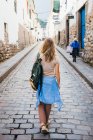 A young woman is walking down the street of the city of Cusco, Peru — Stock Photo