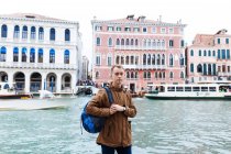 Young blond guy in a brown jacket in middle of streets of Venice — Stock Photo