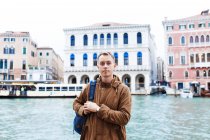 Giovane biondo in giacca marrone in mezzo alle vie di Venezia — Foto stock