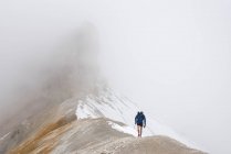 Um turista caminha ao longo do cume da montanha — Fotografia de Stock