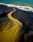Veduta aerea del fiume arancione intrecciato che scorre nell'oceano nel sud — Foto stock