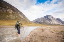 Tourist man exploring Baffin Mountains in Canada. — Stock Photo
