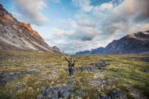 Tourist man exploring Baffin Mountains in Canada. — Stock Photo