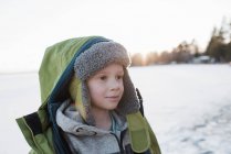 Retrato de menino na praia ao pôr do sol no inverno — Fotografia de Stock