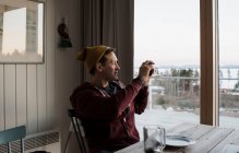 Homem tirando fotos da vista de sua varanda em casa na Suécia — Fotografia de Stock