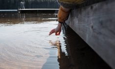 Mano del bambino che sventola acqua di mare sulla spiaggia in Svezia — Foto stock