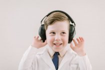 Criança em labcoat com fones de ouvido — Fotografia de Stock