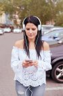 Jovem mulher na Europa ouve música com seus fones de ouvido como sh — Fotografia de Stock