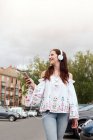 Young woman in Europe listens to music with her headphones as sh — Stock Photo