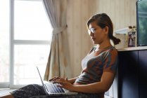 Женщина использует компьютер ноутбук для работы из дома — стоковое фото