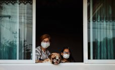 Мать и дочь с собакой остаются дома во время эпидемии COVID-19 — стоковое фото