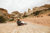 Uomo seduto sul terreno sabbioso nel deserto — Foto stock