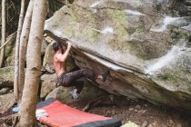 Ein männlicher Bergsteiger erklettert einen Felsen im Freien — Stockfoto