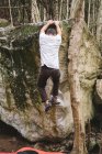 Corpo completo di un arrampicatore maschile che arrampica su una roccia in una foresta — Foto stock