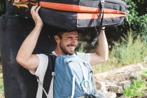 Retrato de un escalador que lleva un crashpad y mochilas - foto de stock