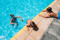 Famille jouant dans une piscine — Photo de stock