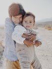 Porträt zweier Kinder, die sich in der Wüste umarmen — Stockfoto