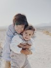 Портрет двох дітей, що обіймаються в пустелі — стокове фото