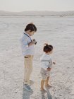 Портрет ребенка, держащего камеру, в то время как рядом стоит другой ребенок — стоковое фото