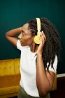 Афроамериканка, яка слухає музику навушниками. — стокове фото