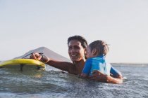 Mãe e filho surfando uma pequena onda no mar — Fotografia de Stock