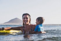 Mutter und Sohn surfen auf einer kleinen Welle auf dem Meer — Stockfoto
