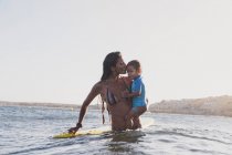Mother and son surfing a small wave at sea — Stock Photo