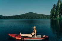 Una giovane donna gode di una tavola da paddle standup sul lago perduto in Oregon. — Foto stock