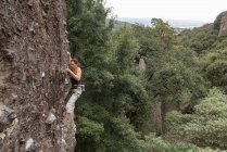 Молодая женщина взбирается на скалу — стоковое фото