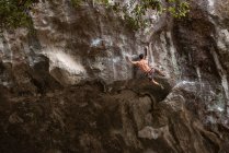 Молодой человек альпинист на скале — стоковое фото
