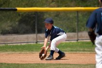 Infielder baseball Little League in campo una palla di terra — Foto stock