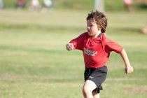 Giovane giocatore di calcio che fa jogging sul campo durante una partita — Foto stock