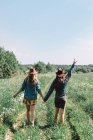Two girls in hats in the field — Stock Photo