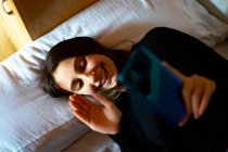 Woman in bed talking on video call. — Stock Photo